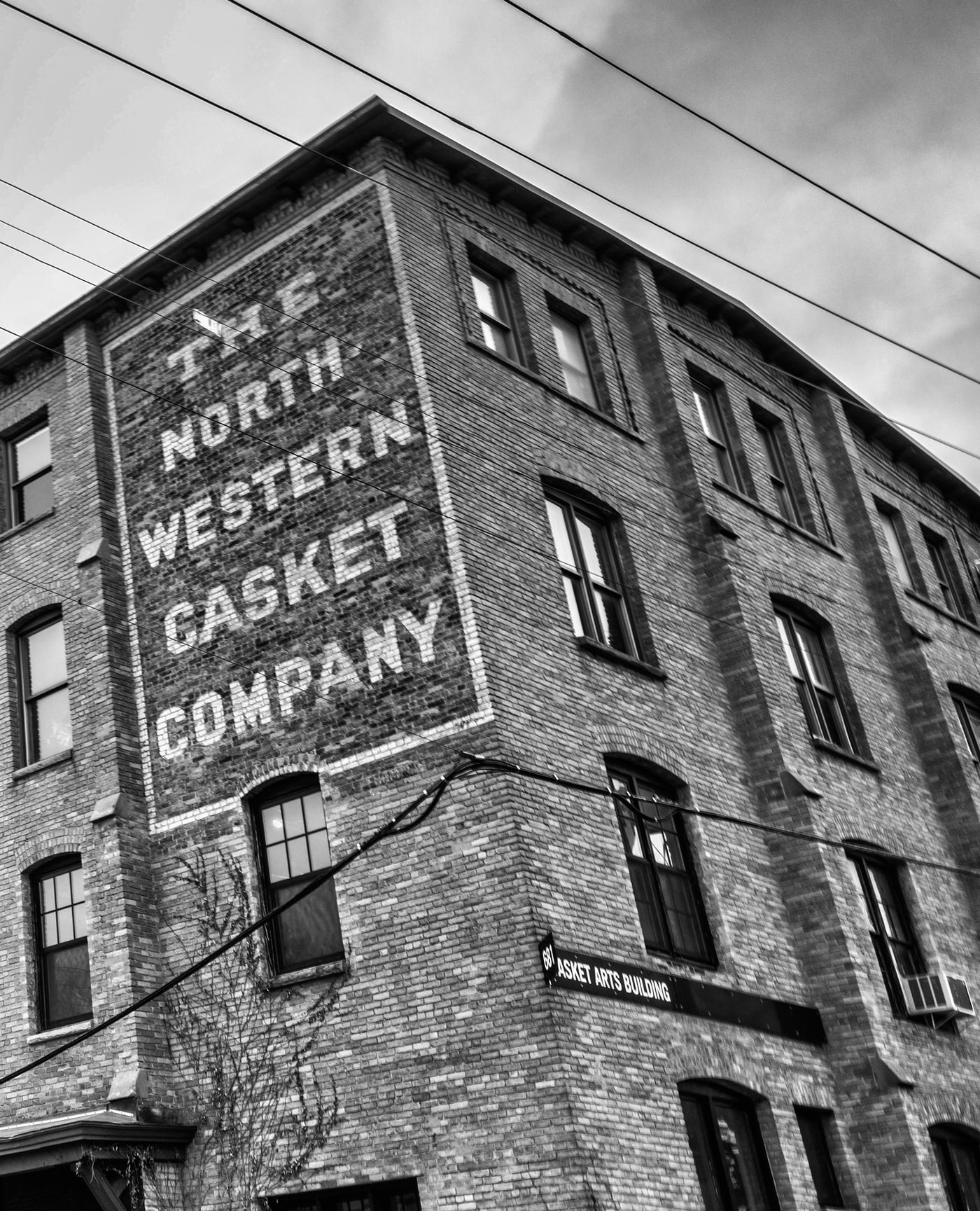 The Northwestern Casket Company ghost sign on the brick facade of the Casket Arts building